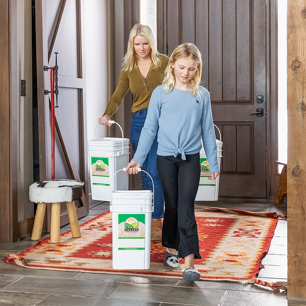 A Lady and a girl carrying the Valley Food Storage Food Kit